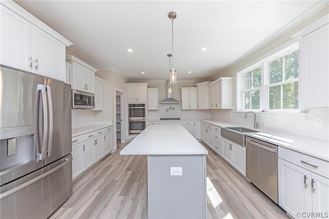 kitchen with stainless steel appliances, wall chimney range hood, light hardwood / wood-style flooring, and backsplash