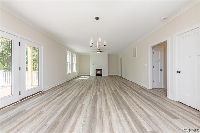 unfurnished living room with an inviting chandelier, ornamental molding, and light hardwood / wood-style floors