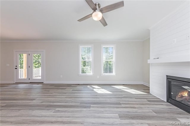 unfurnished living room featuring a healthy amount of sunlight, ceiling fan, light hardwood / wood-style flooring, and a fireplace