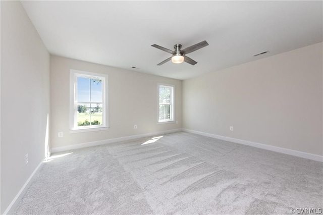 carpeted spare room with a wealth of natural light and ceiling fan