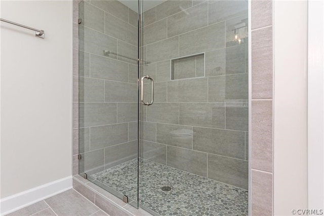 bathroom featuring tile floors and a shower with door