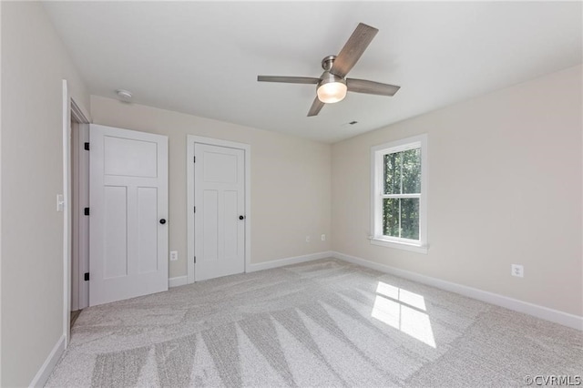 spare room featuring light colored carpet and ceiling fan