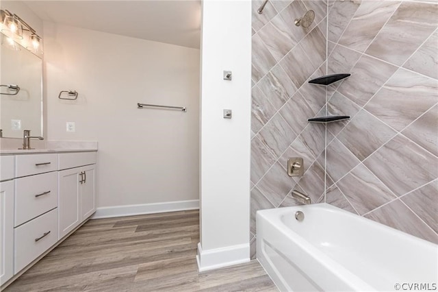 bathroom with tiled shower / bath combo, vanity, and hardwood / wood-style floors