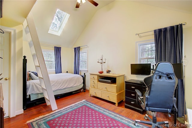 bedroom with multiple windows, hardwood / wood-style floors, a skylight, and ceiling fan