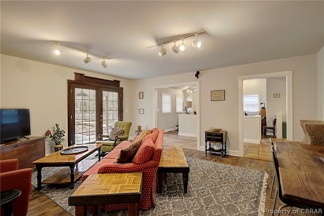 living room with french doors, hardwood / wood-style flooring, and track lighting