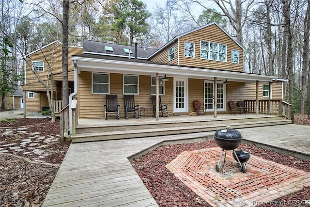 back of house featuring covered porch and ceiling fan