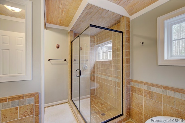 bathroom with plenty of natural light, wood ceiling, and a shower with shower door