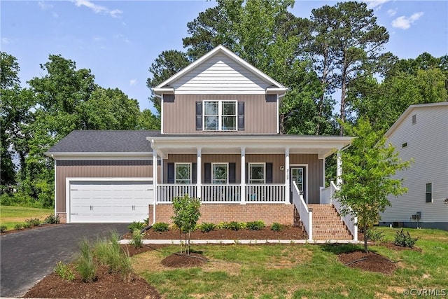 view of front of home with a front yard, covered porch, and a garage