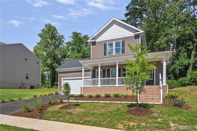 view of front of house featuring covered porch, a garage, and a front lawn