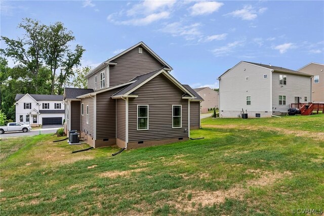 back of property featuring central AC and a lawn