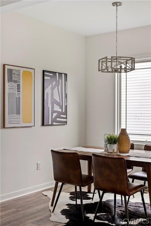 dining space featuring wood-type flooring and a chandelier