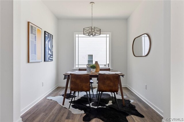 dining area featuring dark hardwood / wood-style flooring and a chandelier