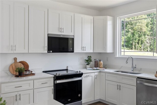 kitchen featuring a wealth of natural light, appliances with stainless steel finishes, sink, and white cabinetry