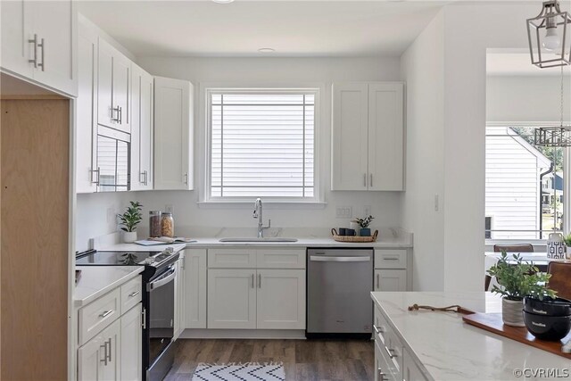 kitchen with sink, pendant lighting, stainless steel appliances, and white cabinetry