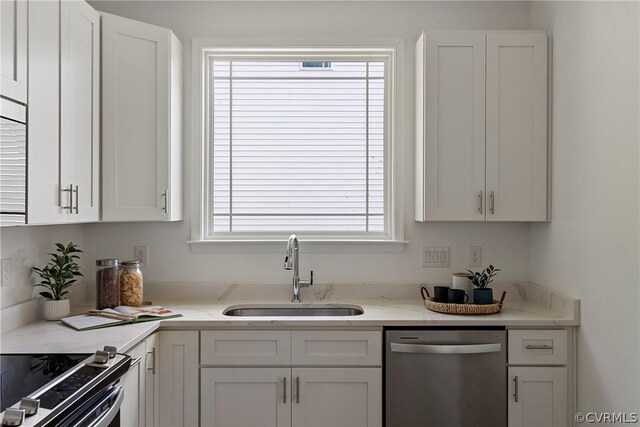 kitchen featuring light stone countertops, sink, white cabinets, and appliances with stainless steel finishes