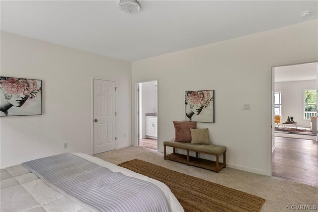 bedroom with light carpet and ensuite bath