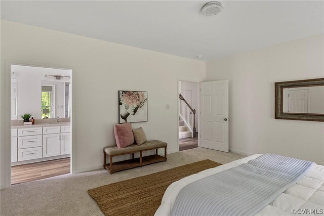 carpeted bedroom featuring sink and connected bathroom