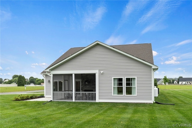 back of house with a lawn and a sunroom