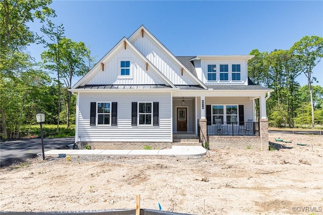 view of front of house with a standing seam roof, a porch, board and batten siding, and metal roof
