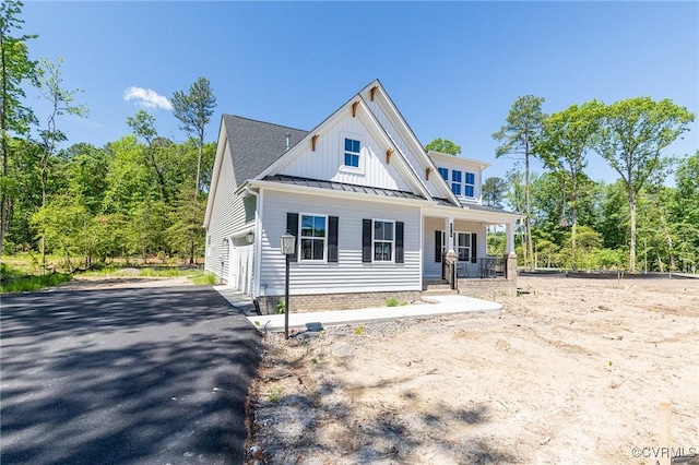 view of front of house featuring a standing seam roof, metal roof, a porch, and board and batten siding