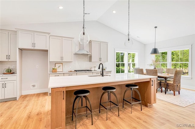 kitchen featuring a sink, light wood-style floors, decorative backsplash, light countertops, and recessed lighting