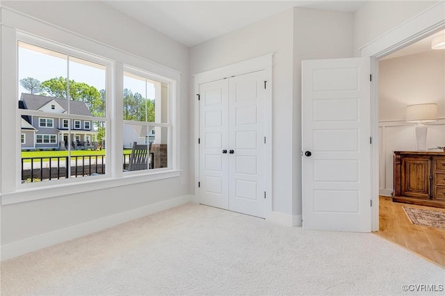 unfurnished bedroom with carpet, a closet, and baseboards