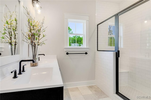 bathroom featuring a stall shower, baseboards, double vanity, and tile patterned floors