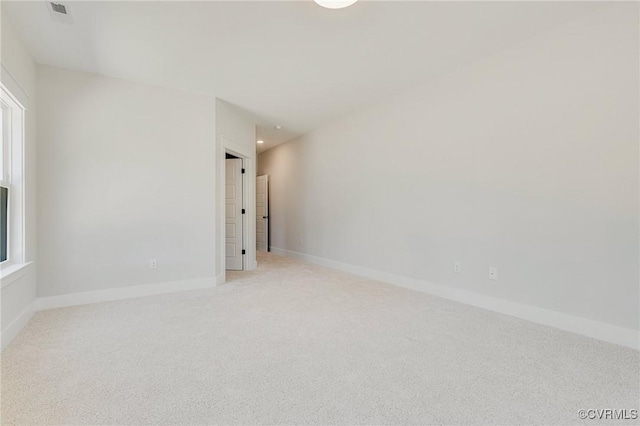 empty room with light colored carpet and baseboards