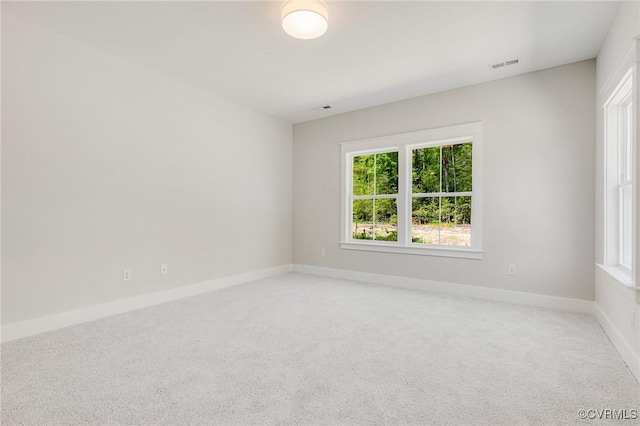 unfurnished room with light carpet and baseboards