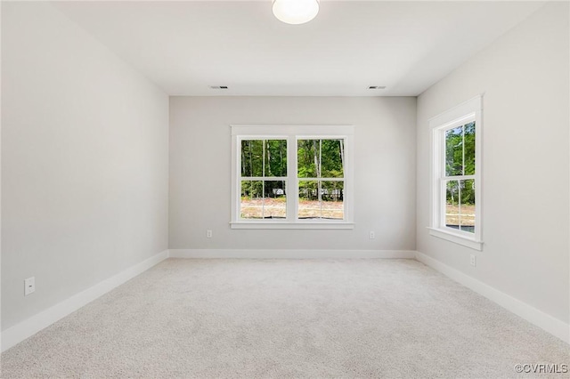 unfurnished room with light carpet and baseboards