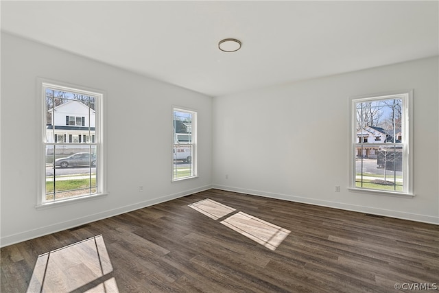 unfurnished room with dark wood-type flooring and a wealth of natural light