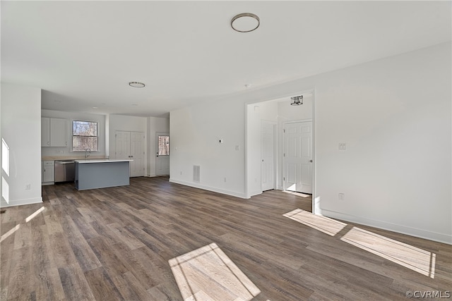 unfurnished living room with dark hardwood / wood-style floors and sink