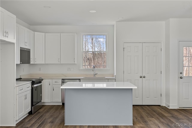 kitchen with white cabinets, sink, electric stove, and dark hardwood / wood-style flooring