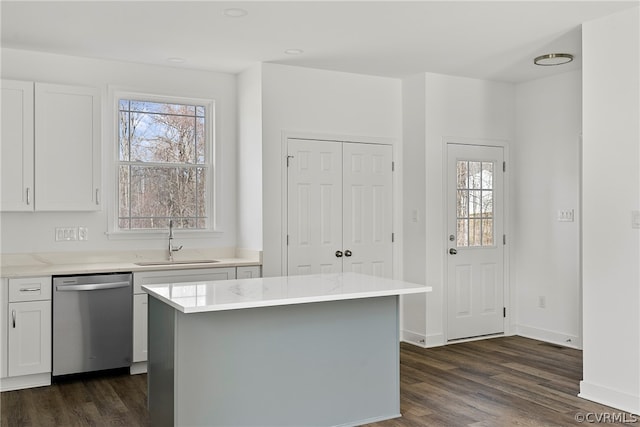 kitchen featuring dark hardwood / wood-style flooring, white cabinetry, stainless steel dishwasher, and sink