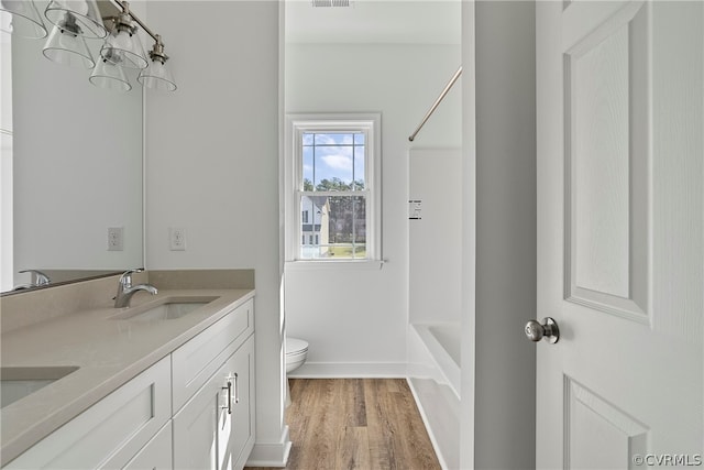 full bathroom with shower / bathtub combination, toilet, double vanity, and wood-type flooring