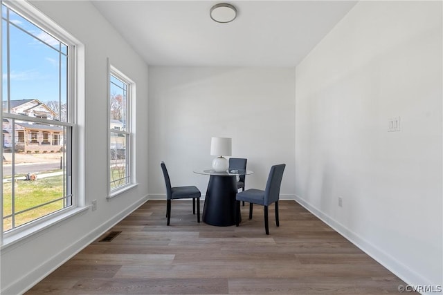 dining space with wood finished floors, baseboards, and visible vents