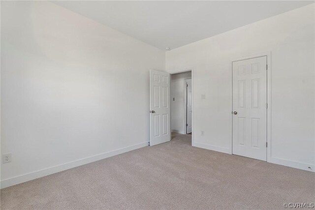 unfurnished bedroom featuring baseboards and light carpet