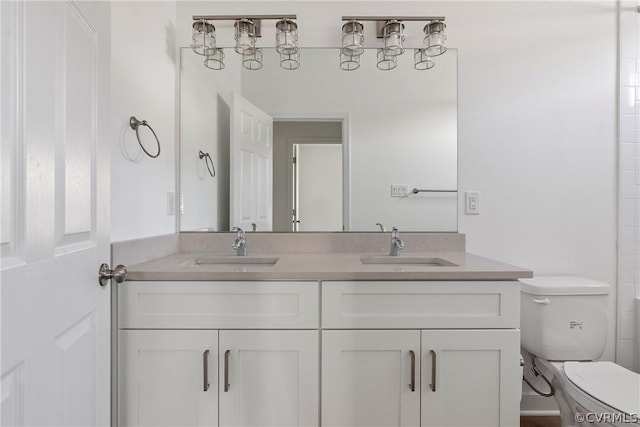 full bathroom featuring double vanity, toilet, and a sink