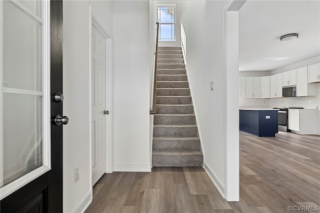 stairway with light hardwood / wood-style floors