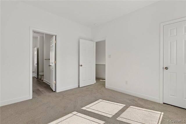 unfurnished bedroom featuring carpet flooring and ensuite bath