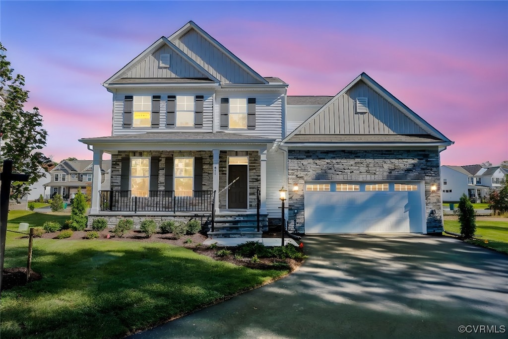 craftsman inspired home with a yard and covered porch