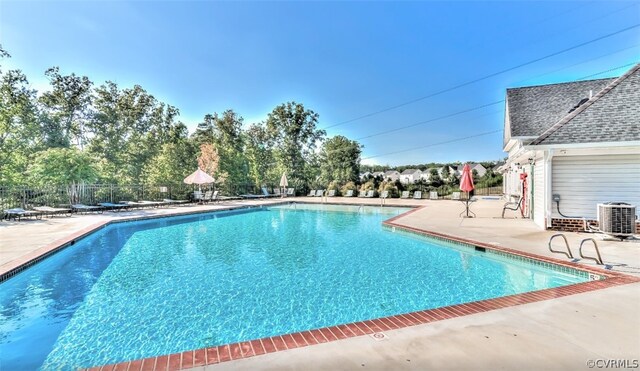 view of swimming pool featuring central AC unit and a patio