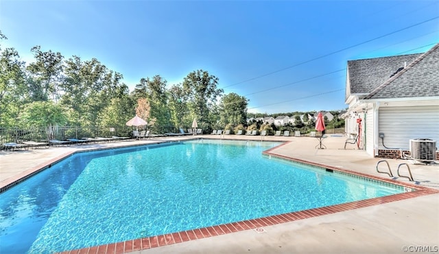 pool featuring fence, central AC, and a patio