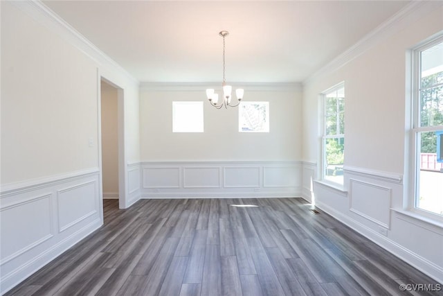 spare room with dark wood-style floors, a decorative wall, a chandelier, and crown molding