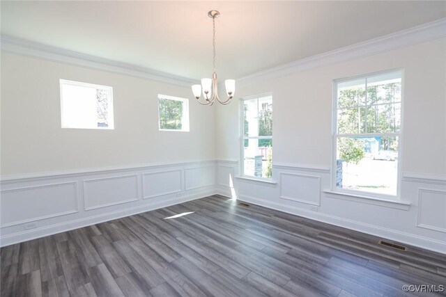 unfurnished dining area featuring ornamental molding, dark hardwood / wood-style flooring, and a chandelier