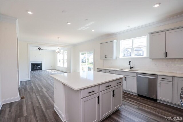 kitchen featuring stainless steel dishwasher, sink, dark hardwood / wood-style floors, and backsplash