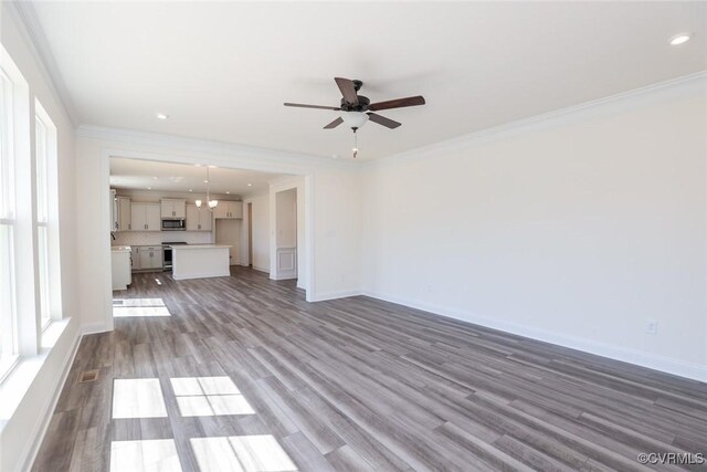 unfurnished living room with ceiling fan, hardwood / wood-style flooring, and ornamental molding