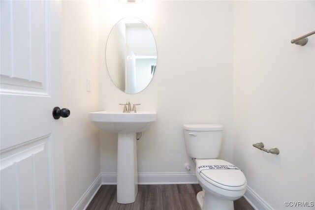 bathroom with toilet and wood-type flooring