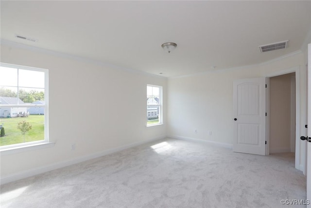 unfurnished room with light carpet, baseboards, visible vents, and crown molding