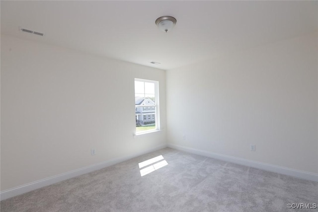 unfurnished room featuring carpet, visible vents, and baseboards